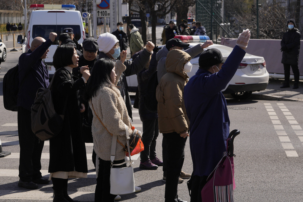 Family members of passengers on board the missing Malaysian Airline MH370 shout slogans near the Malaysian embassy in Beijing