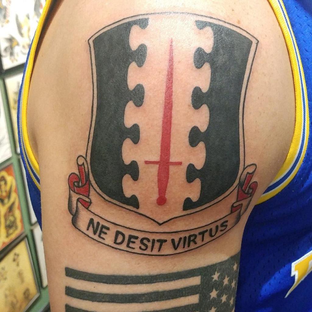 Most of Hegseth's shoulder is taken up by the insignia of his army regiment.