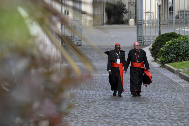 Cardinals Dieudonné Nzapalainga, left, and Timothy M. Dolan arrive for the Congregation of Cardinals 