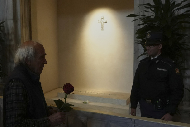 A faithful holds a rose infant of the tomb of Pope Francis inside St. Mary Major Basilica in Rome