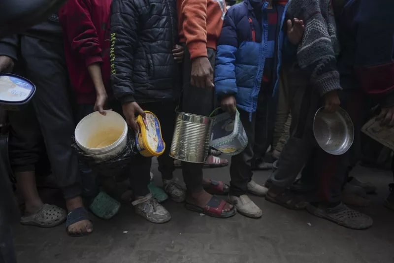 Palestinian children queue at a food distribution kitchen in Deir al-Balah, Gaza Strip, 