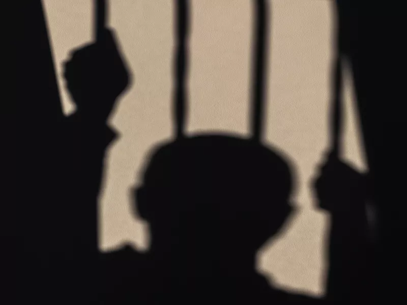 Σκιά φυλακισμένου πίσω από κάγκελα
