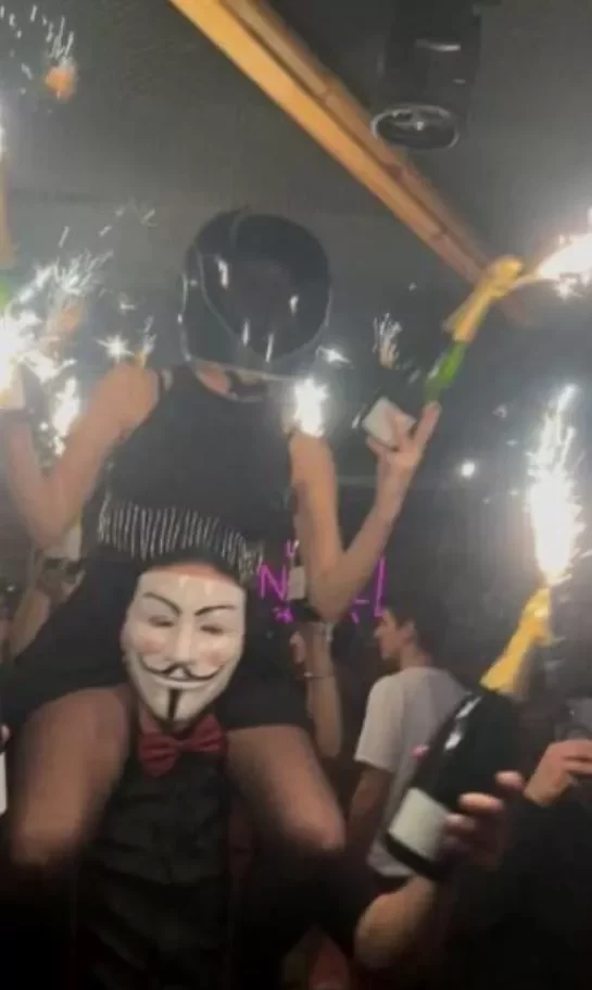 Κραν Μοντανά: Φωτογραφία δείχνει γυναίκα στους ώμους άνδρα να κρατά βεγγαλικά σε μπουκάλι σαμπάνιας